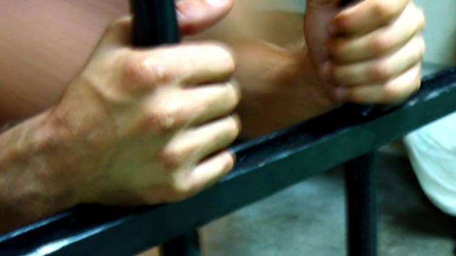 prison bars close hands.jpg